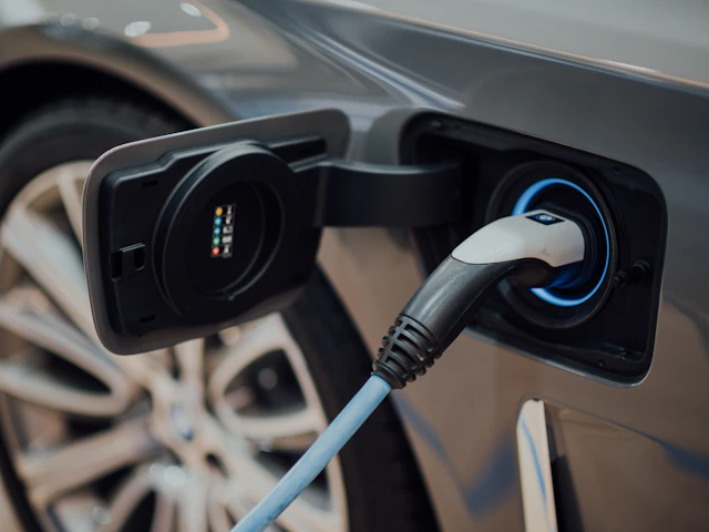 Wtyczka ładowania podłączona do gniazda w samochodzie elektrycznym